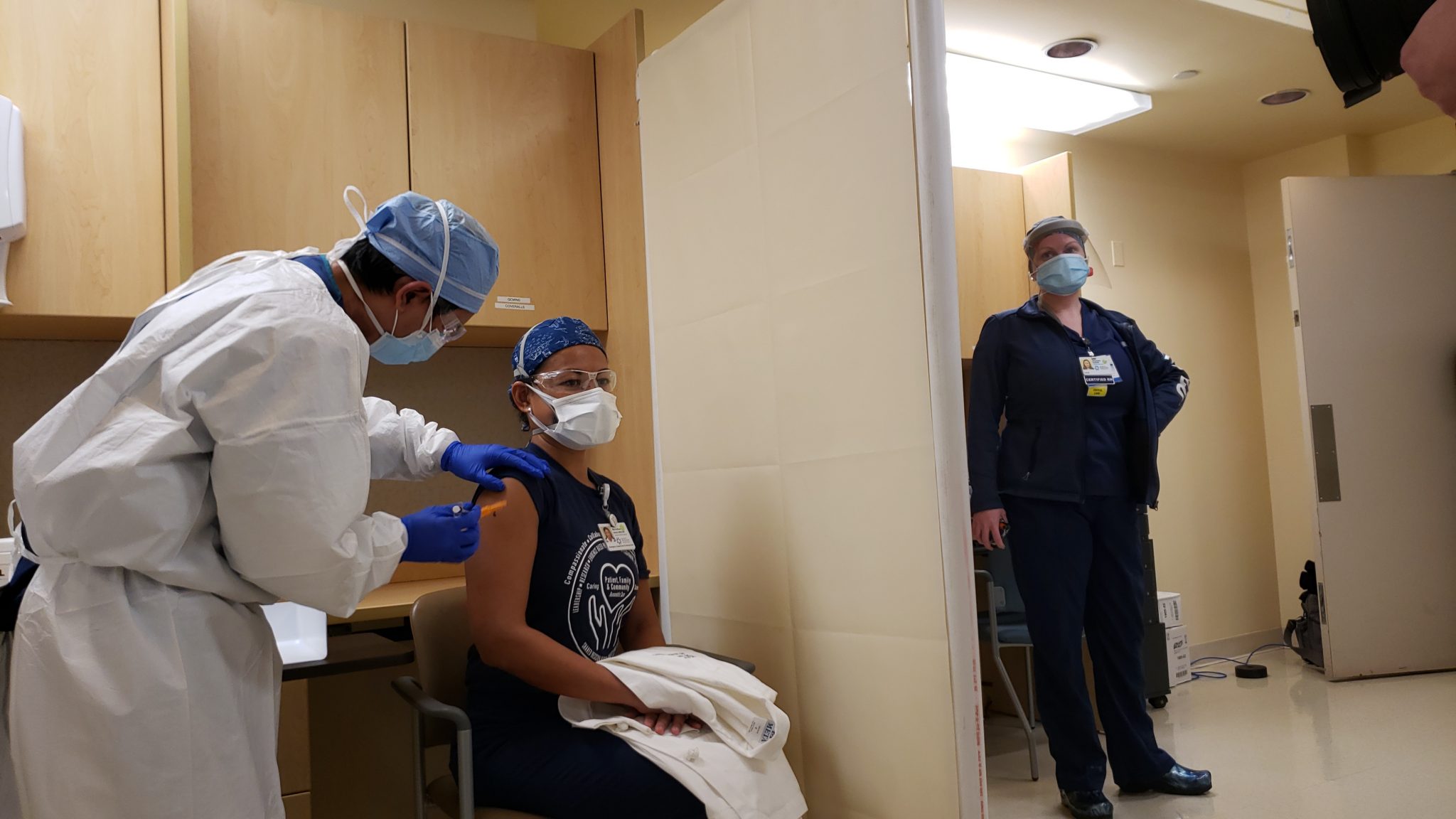 With a smile and thumbs up, five team members at JFK Medical Center receive first doses of Pfizer-BioNTech COVID-19 vaccine