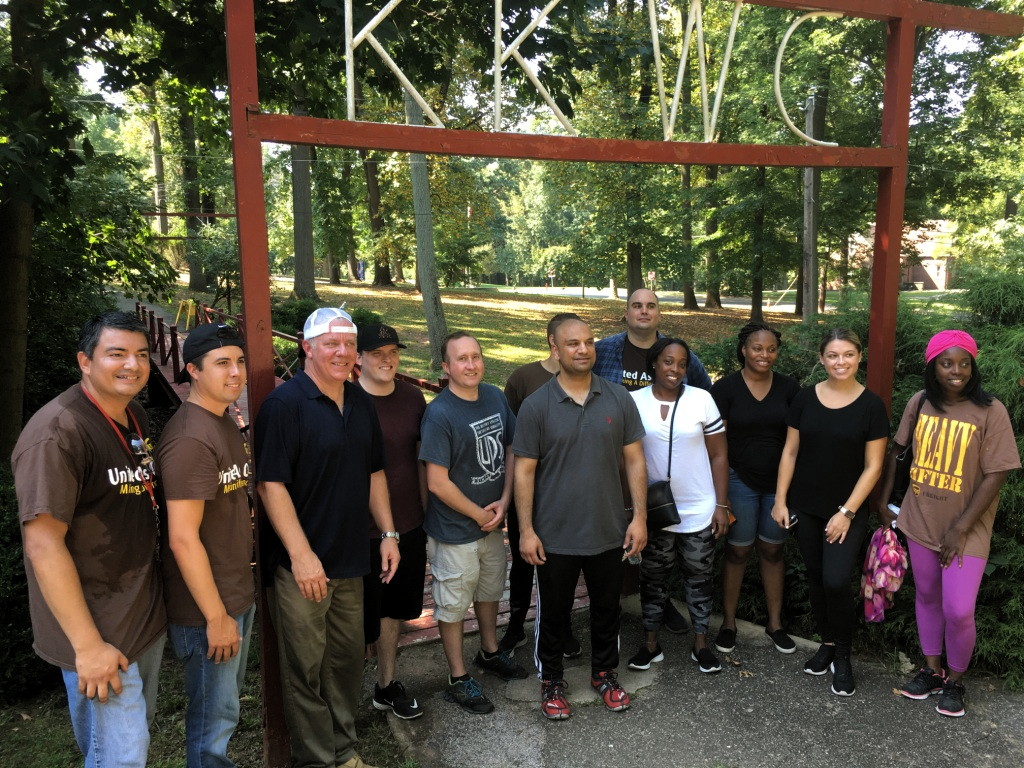 Volunteers from UPS, United Way of Central Jersey beat the heat to clean up camp in Roosevelt Park