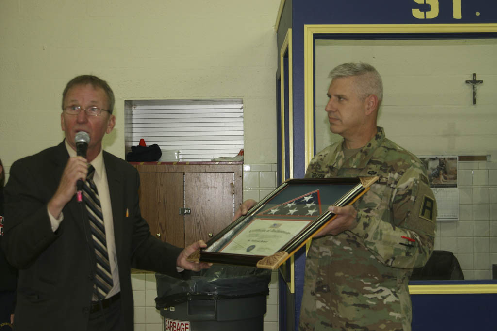 Parent presents flag flown in Afghanistan to St. Ambrose School